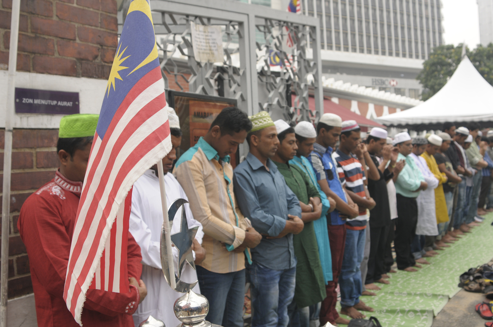 Muslims praying together on on Aidil Adha