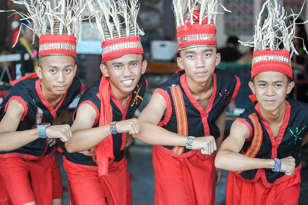 young men from dusun keningau tribe gesturing happy harvest festival - sabah