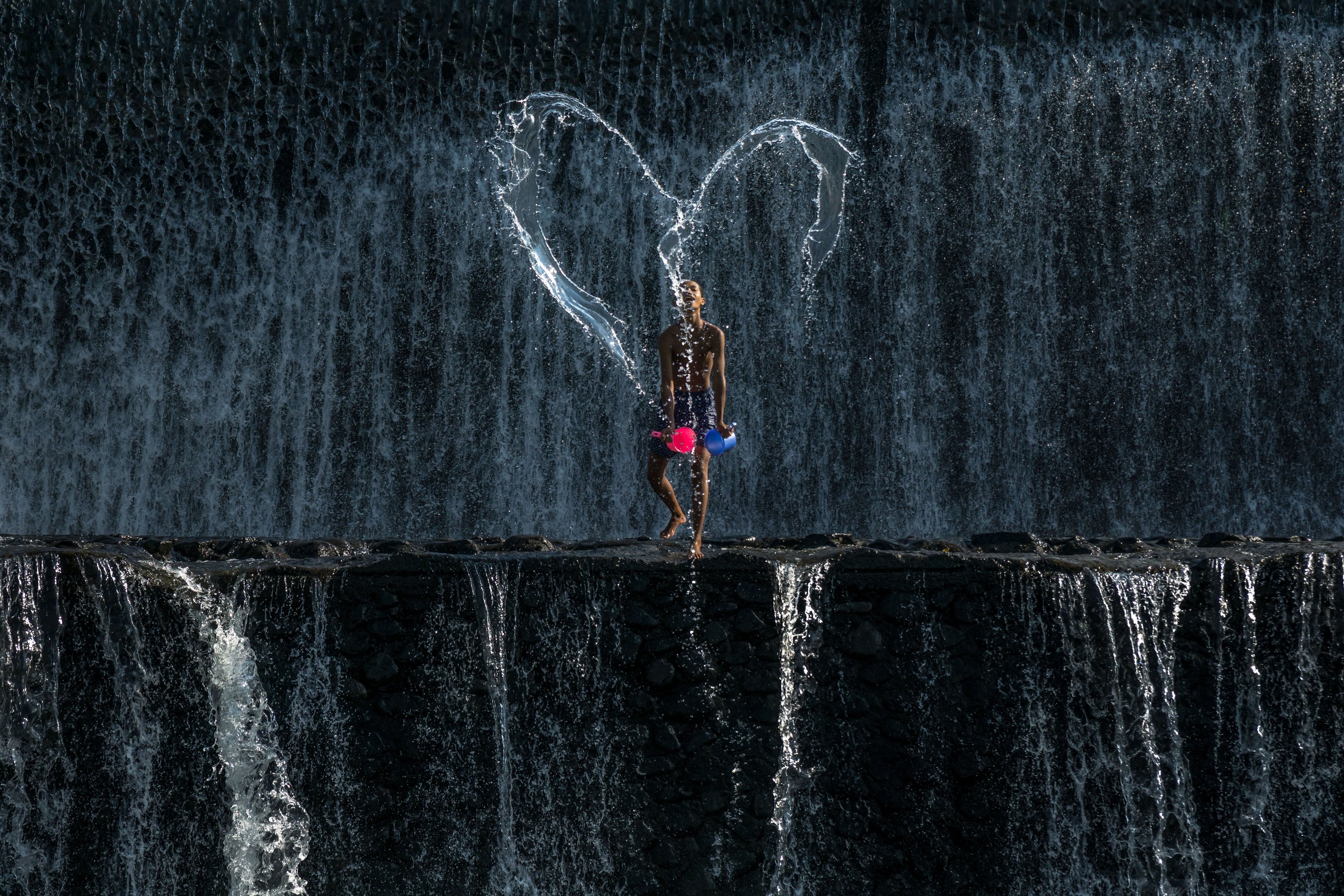 A boy creatively made a LOVE shape at the River of Tukad Yeh Unda in Klungkung Sub-District, Klungkung Regency, Bali, Indonesia.