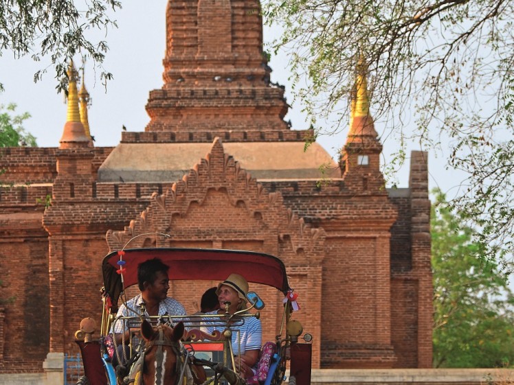 A horse-drawn carriage and small village temple