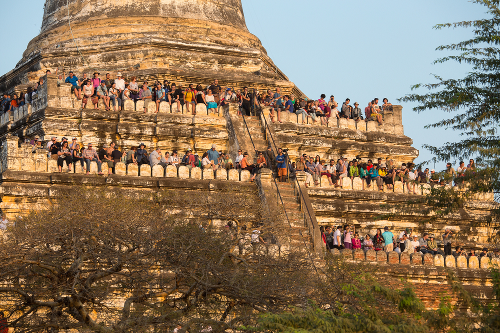Tourists on a pagoda in Bagan taking photos of the sunset