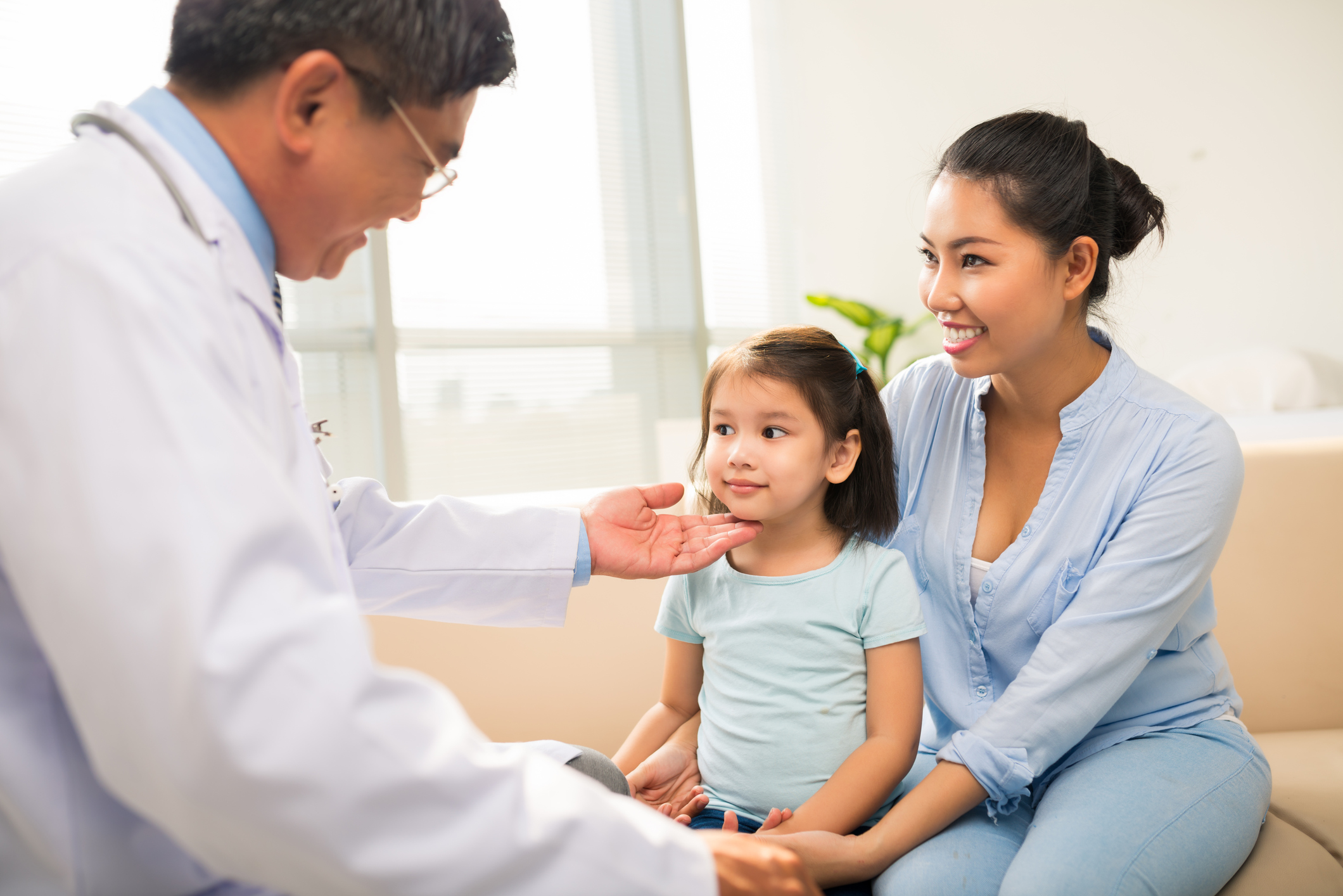 Asian girl and her mother visiting office of pediatrician