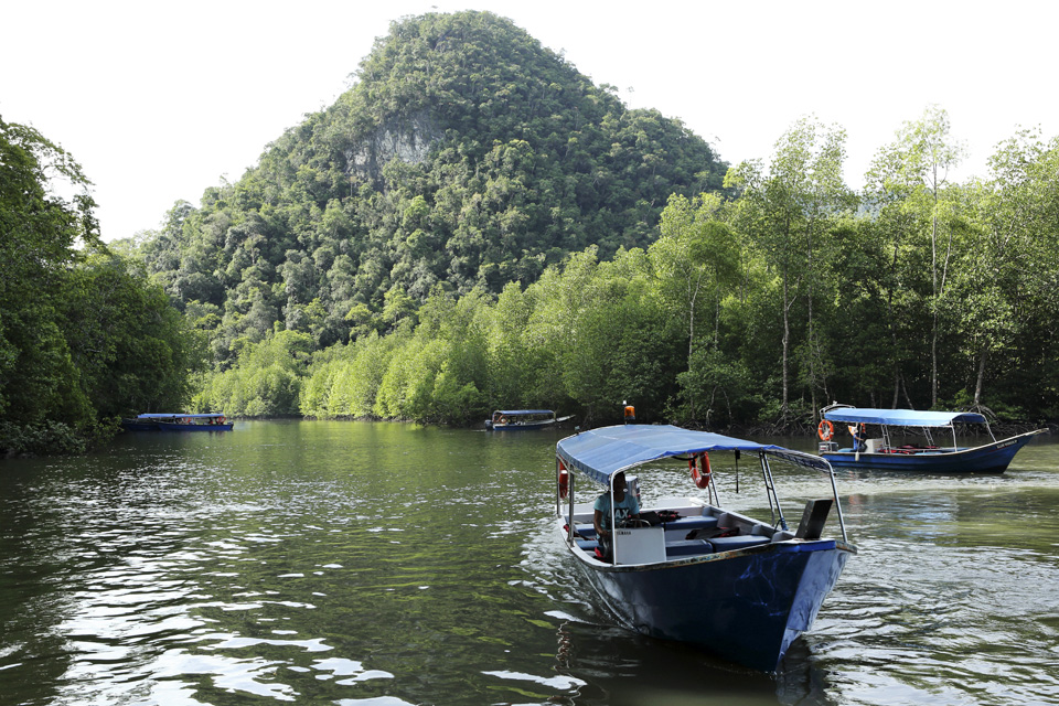 Boats on a waterway in Kelim Karst Geoforest Park on Langkawi, Malaysia. The park on the island's east is set among mangrove forest and limestone hills, gorges and islands.