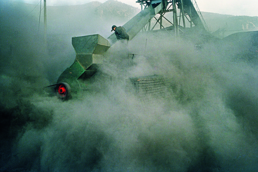 Worker in a small coal mine. China is the largest coal user in the world, it also claims the most unenviable record, that of the highest number of coal miners with lung problems. Black lung disease is the result of the lungs being coated with coal dust as miners work at the coal-face hacking out the coal, or elsewhere shifting the lumps of coal or mining waste. The name, black lung, comes from the distinctive blue-black marbling of the lung from the coal dust accumulation. This disease occurs mostly in those who mine hard coal (anthracite), but also occurs among those mining soft coals and graphite. After about ten to twenty years of exposure, symptoms to set in and it may be aggravated by silica (causing silicosis) mixed with the coal. Shanxi, China. 2006.