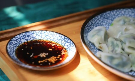 soy sauce in a flat dish with sesame seeds