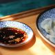 soy sauce in a flat dish with sesame seeds