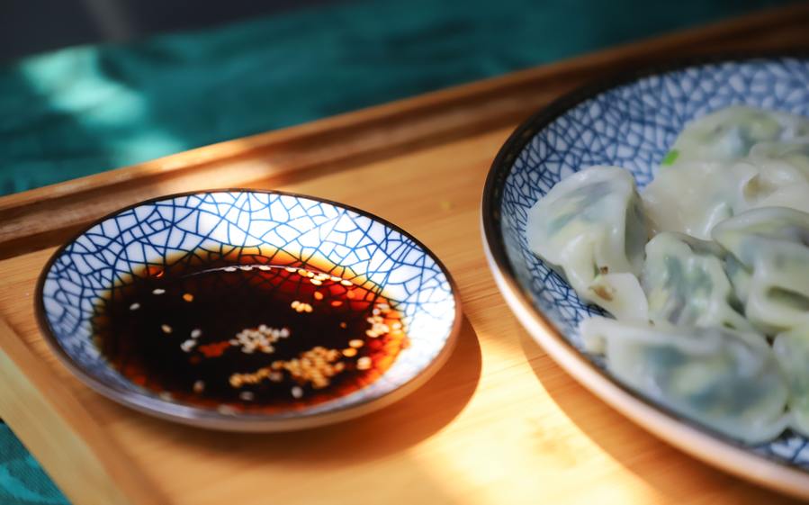 soy sauce in a flat dish with sesame seeds